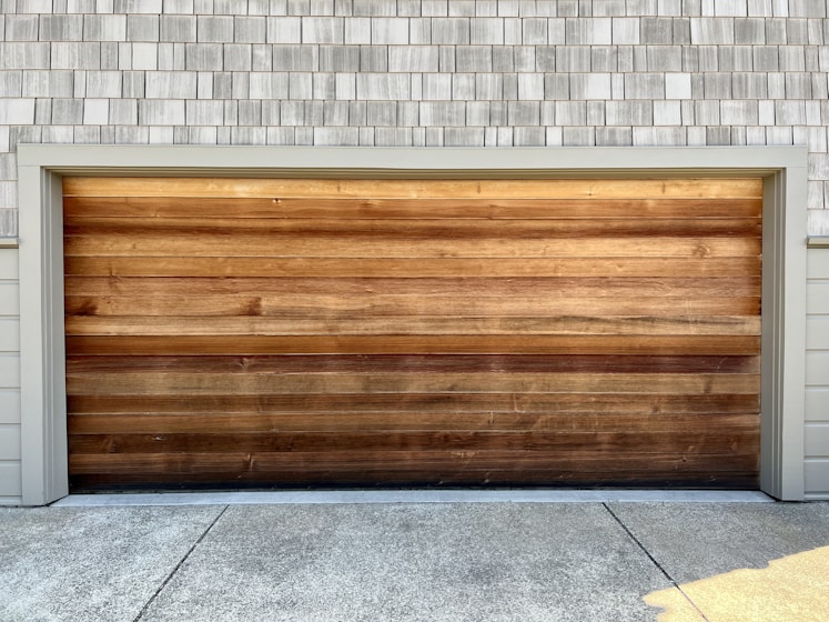 a wooden garage door on a brick building