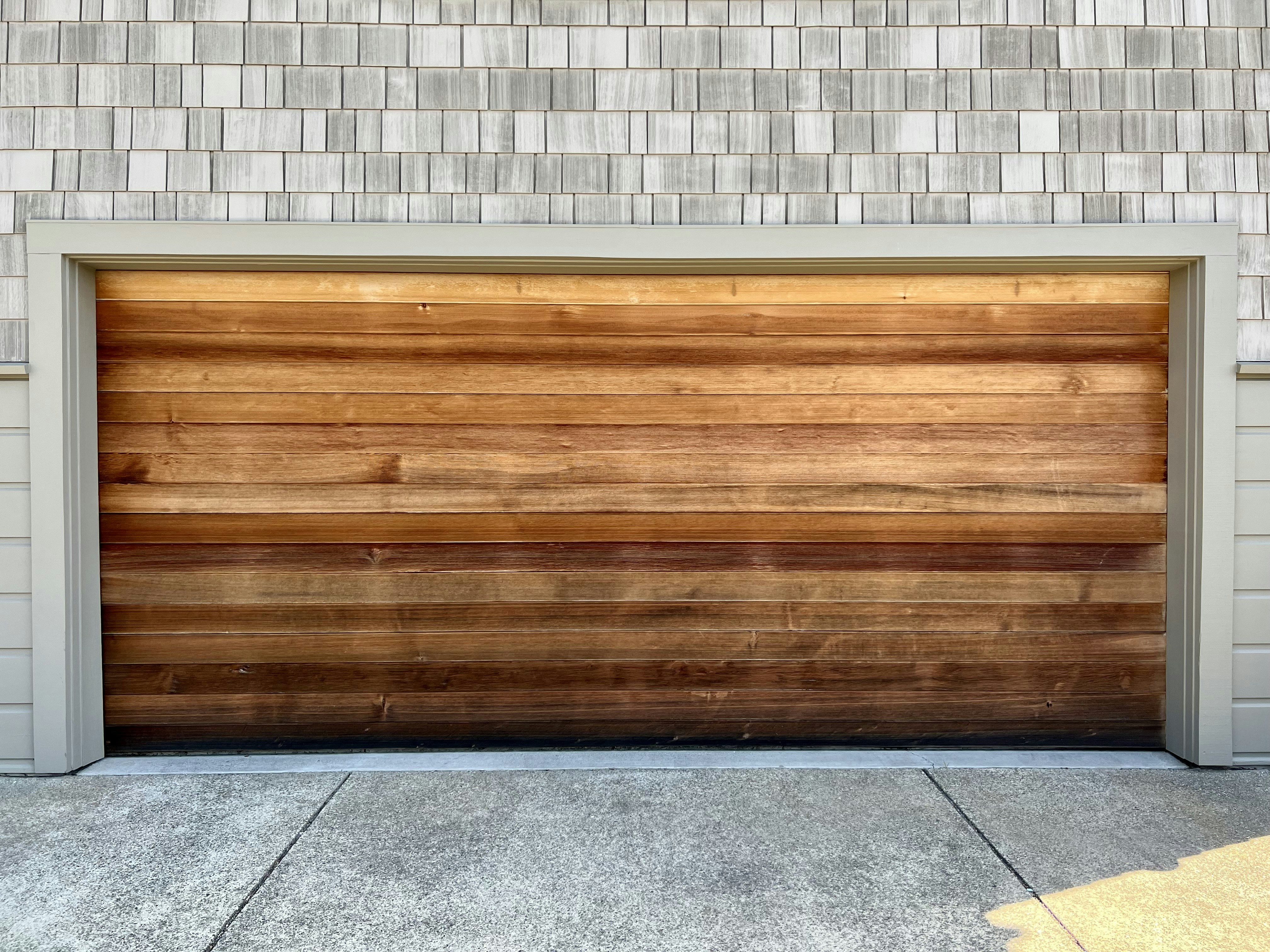 a wooden garage door on a brick building