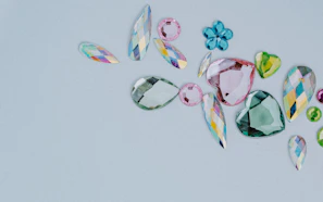 A selection of radiant loose gemstones in various cuts and colors, artfully placed on a minimalist white surface.