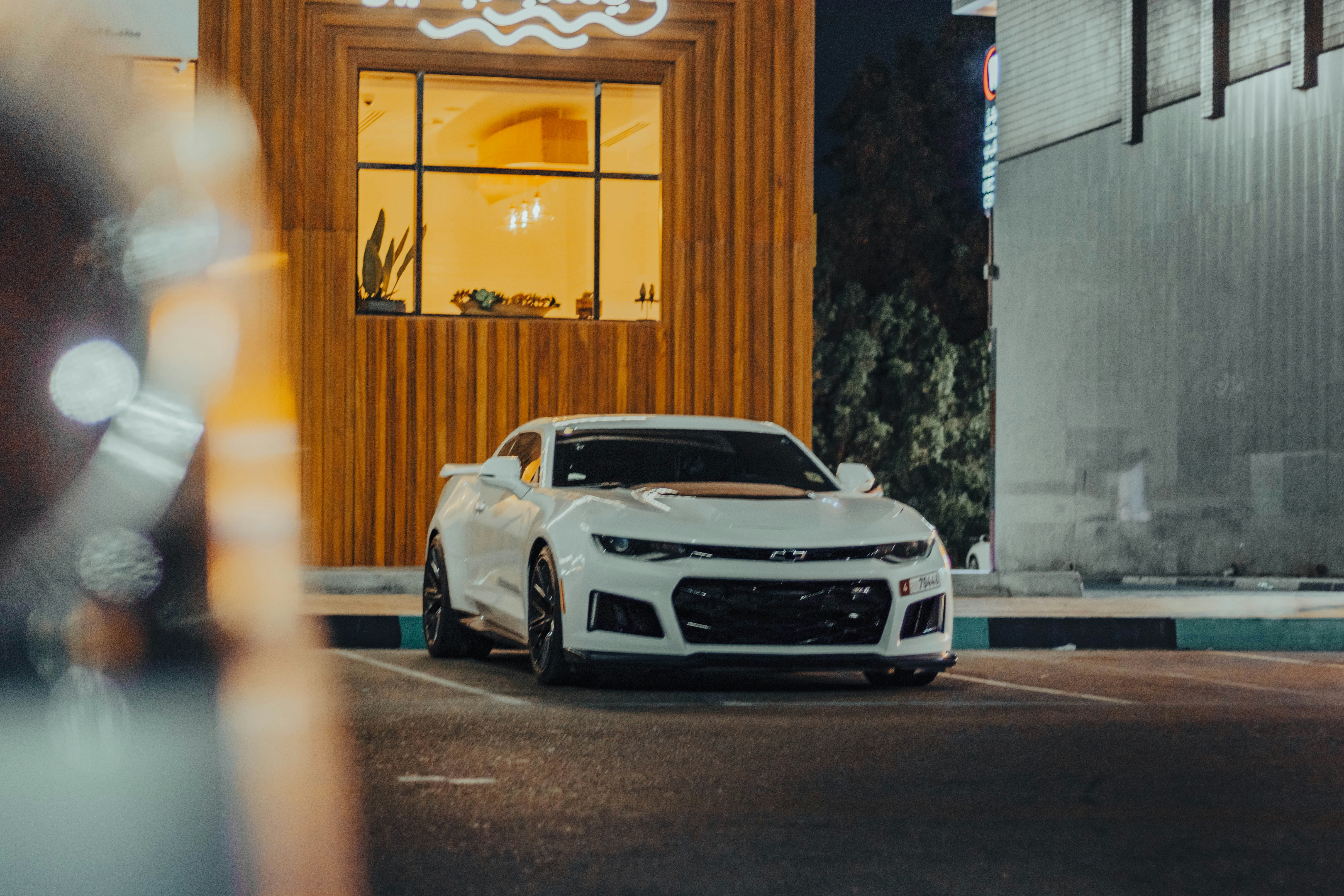 A white car parked in front of a building photo – Free Brown Image on ...