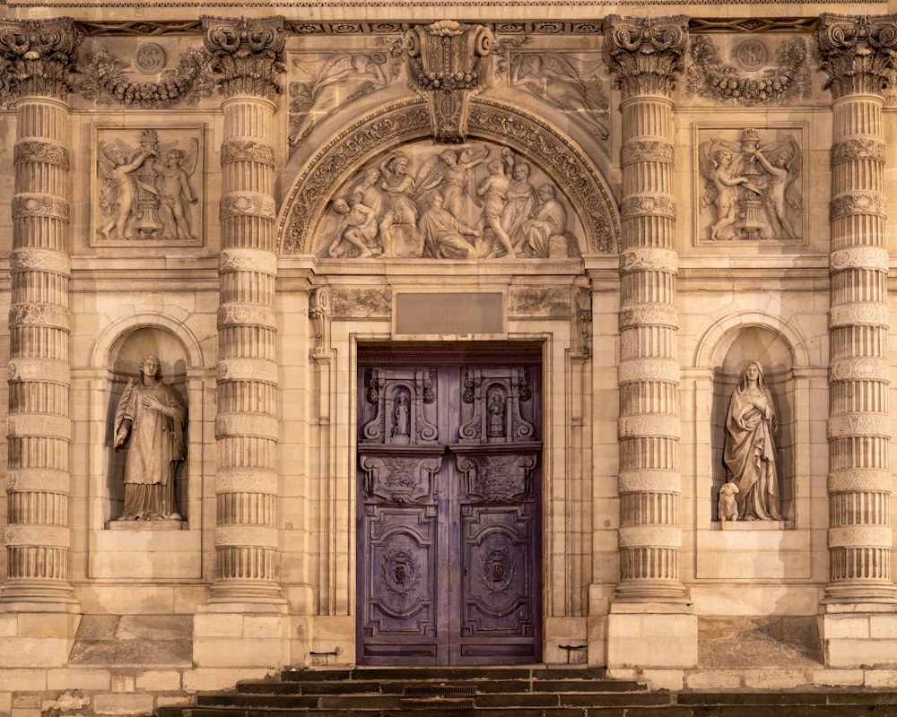 un grand bâtiment avec une porte violette et des marches