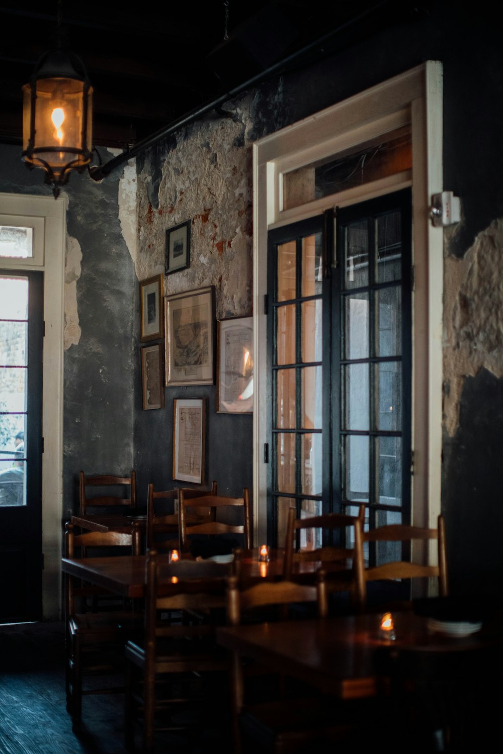 a dimly lit restaurant with wooden tables and chairs