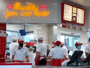 a group of people standing in line at a fast food restaurant