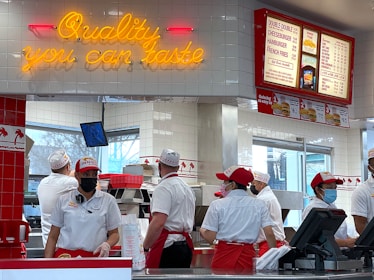 a group of people standing in line at a fast food restaurant