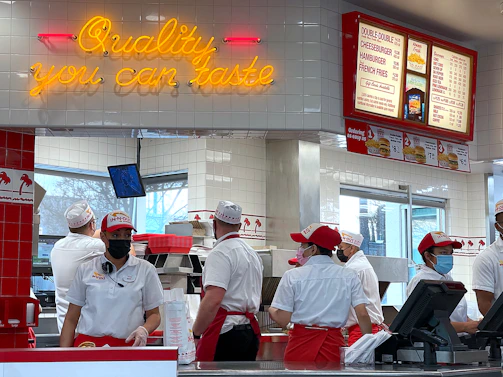 a group of people standing in line at a fast food restaurant
