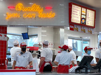 a group of people standing in line at a fast food restaurant