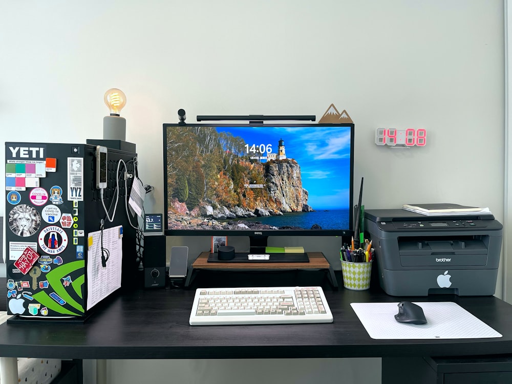 a desk with a computer and printer on it