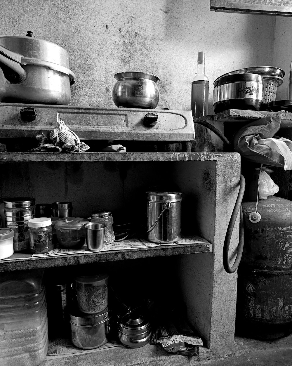 a black and white photo of a kitchen with pots and pans