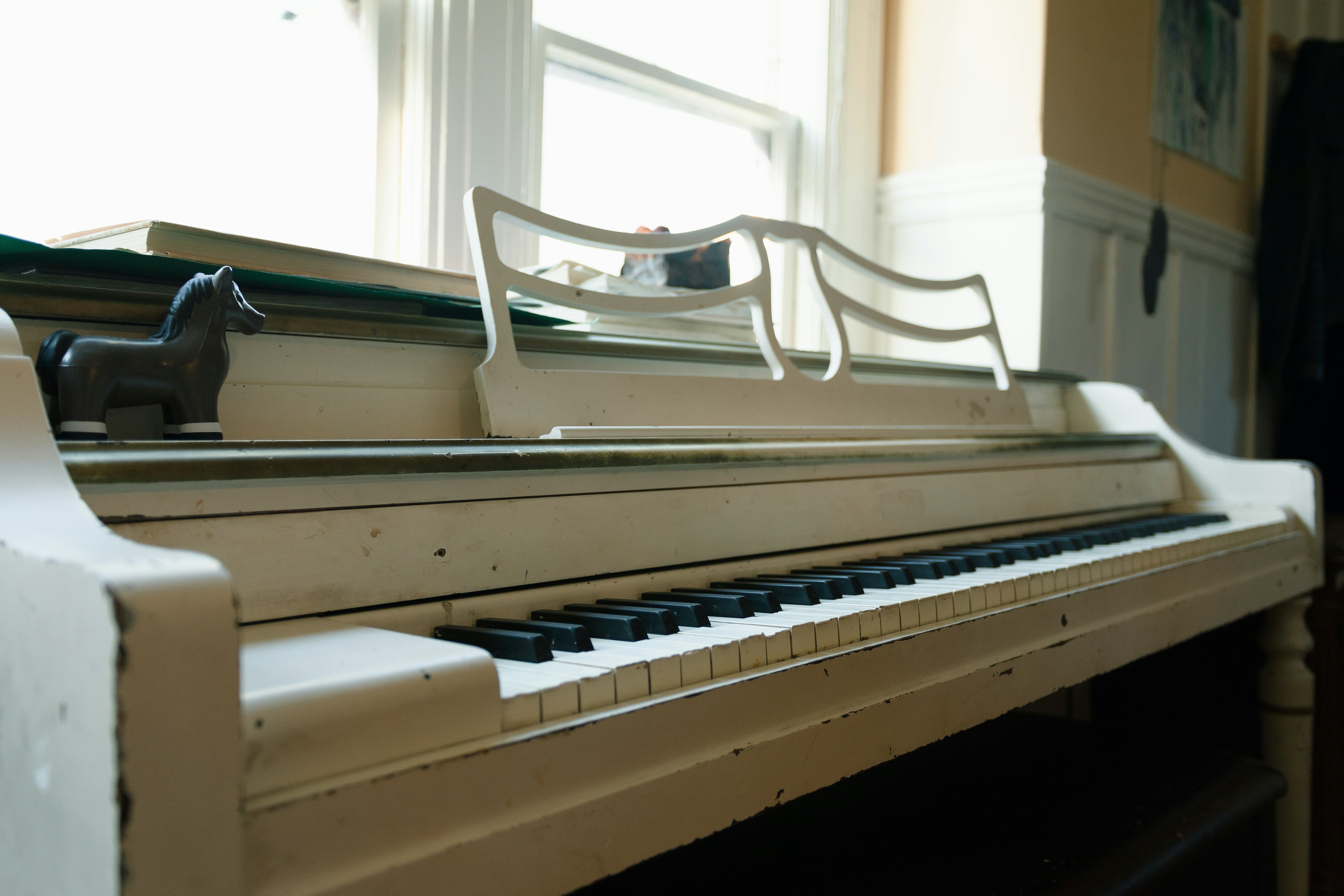 a toy horse sitting on top of a piano