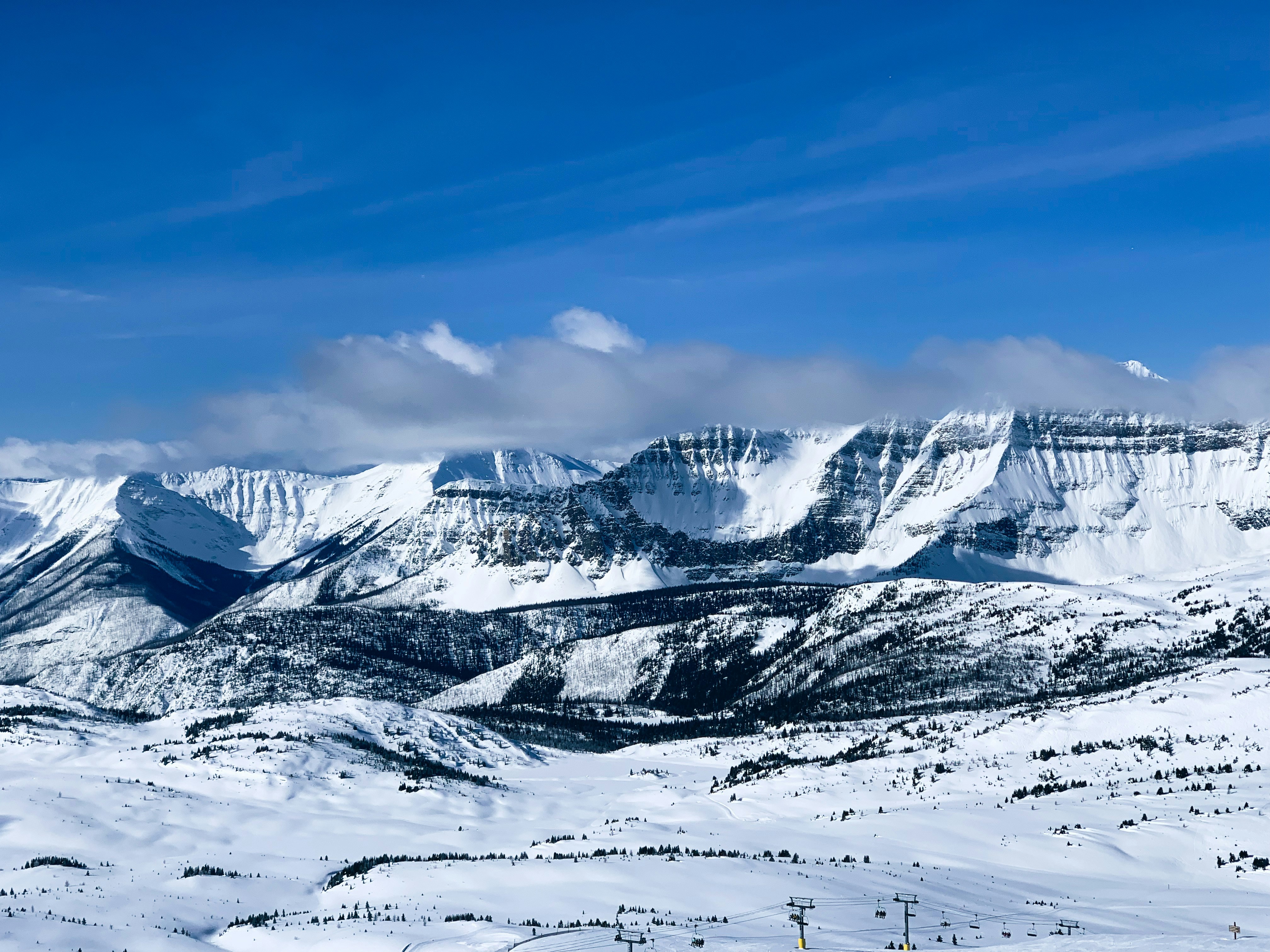 a mountain range covered in snow under a blue sky