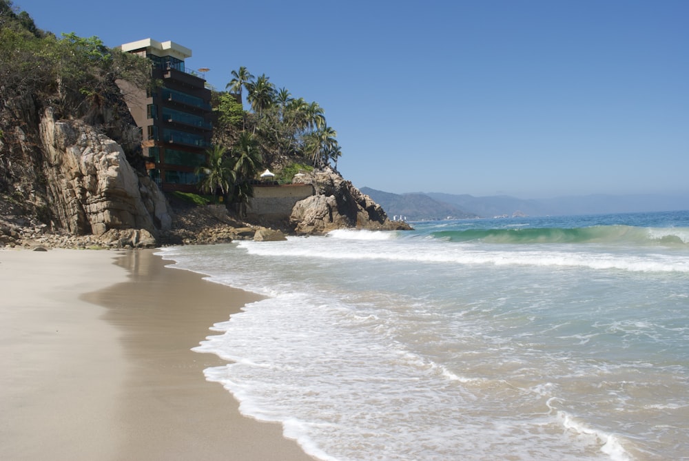 uma vista de uma praia com um penhasco no fundo