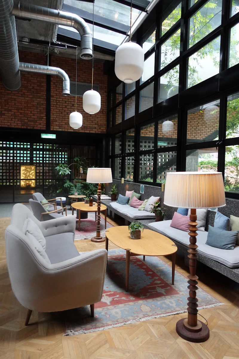 The lobby lounge: linen sofas, pleated lamps and a wall of glass onto the garden