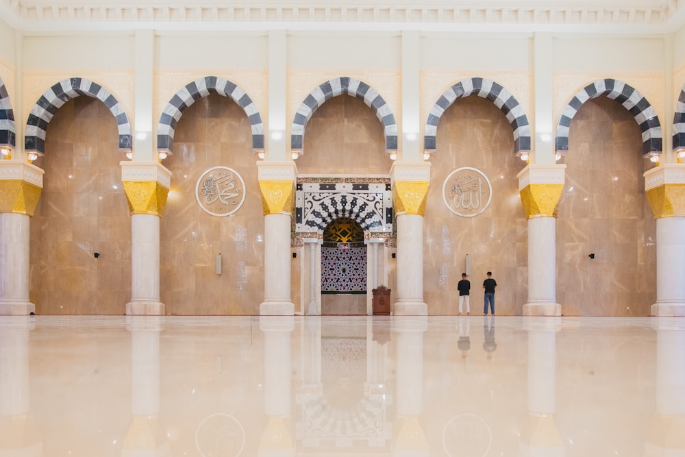 a couple of people standing in a large building