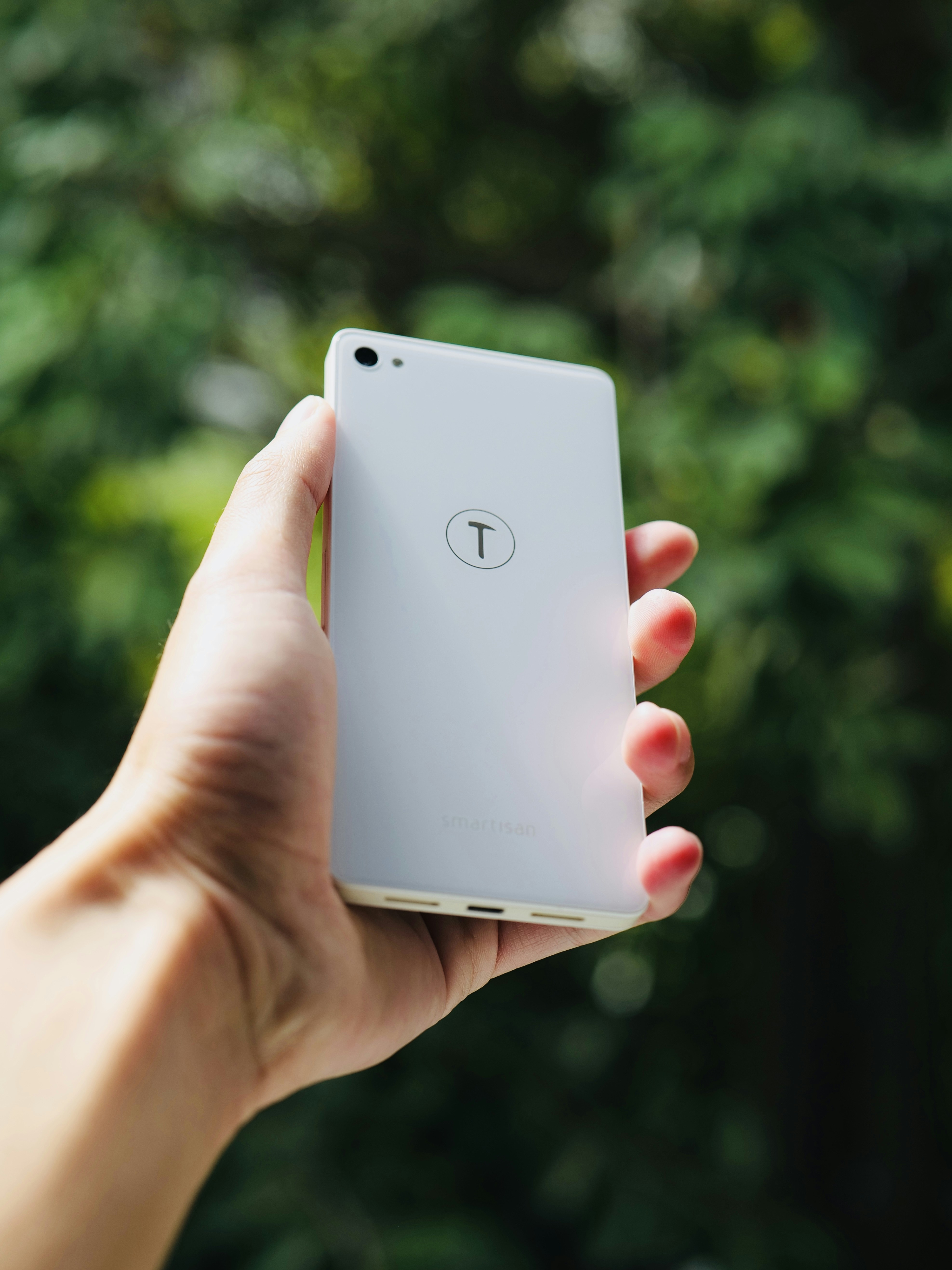 a person holding a white cell phone in their hand