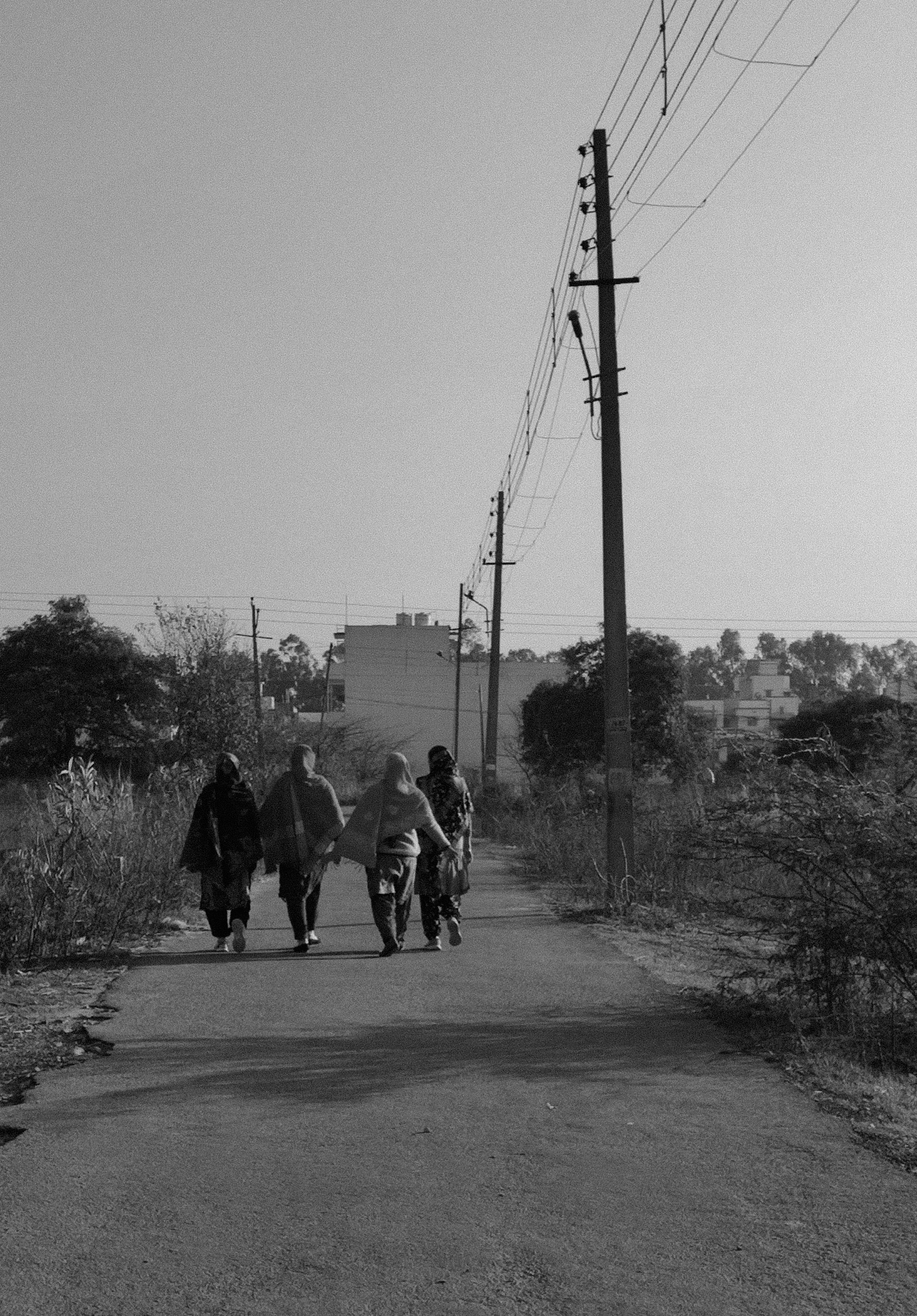 um grupo de pessoas andando por uma estrada de terra