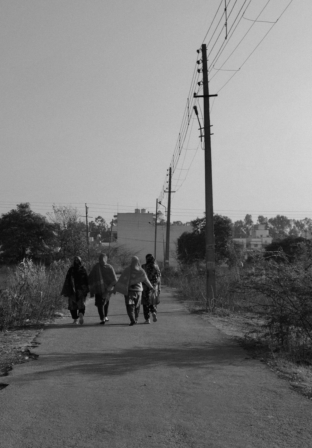 a group of people walking down a dirt road