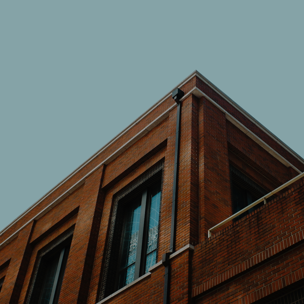 a tall brick building with a clock on the top of it