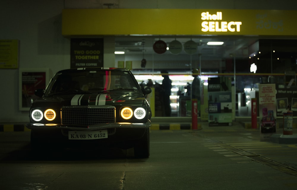 a car parked in front of a store at night