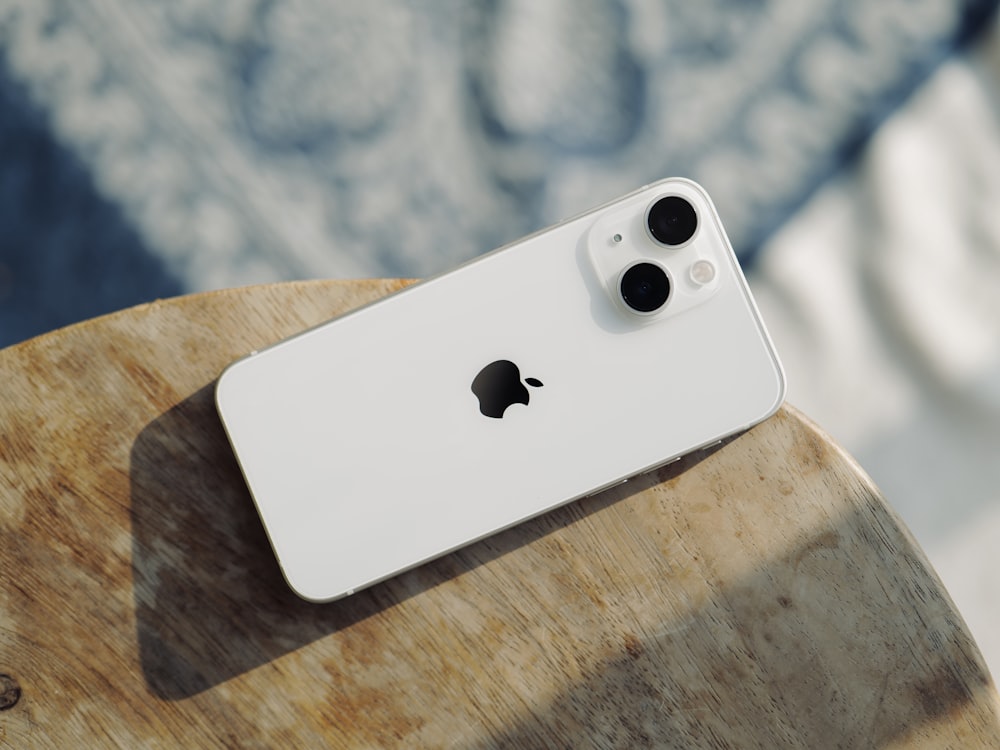 a white iphone sitting on top of a wooden table