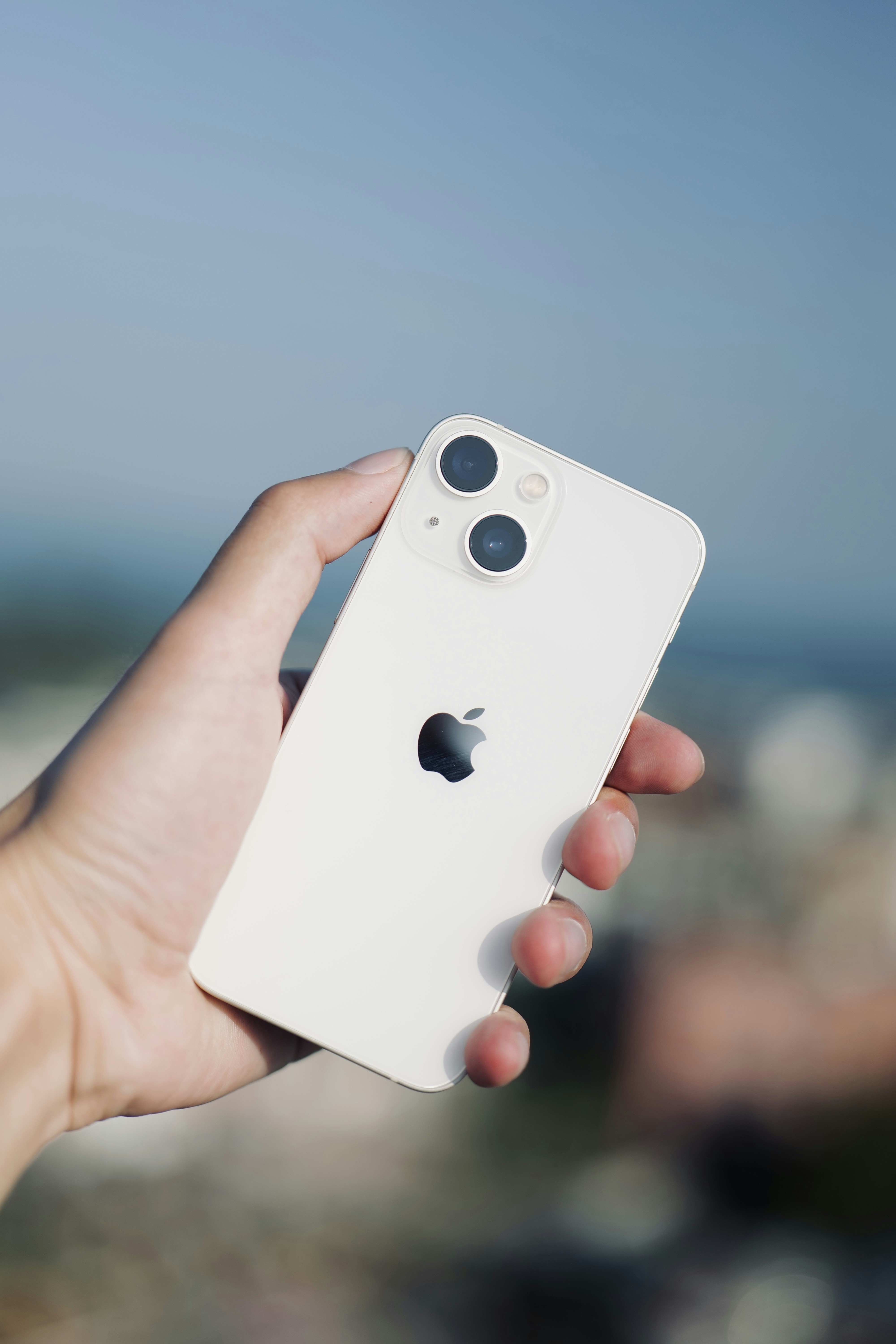 a person holding a white iphone in their hand