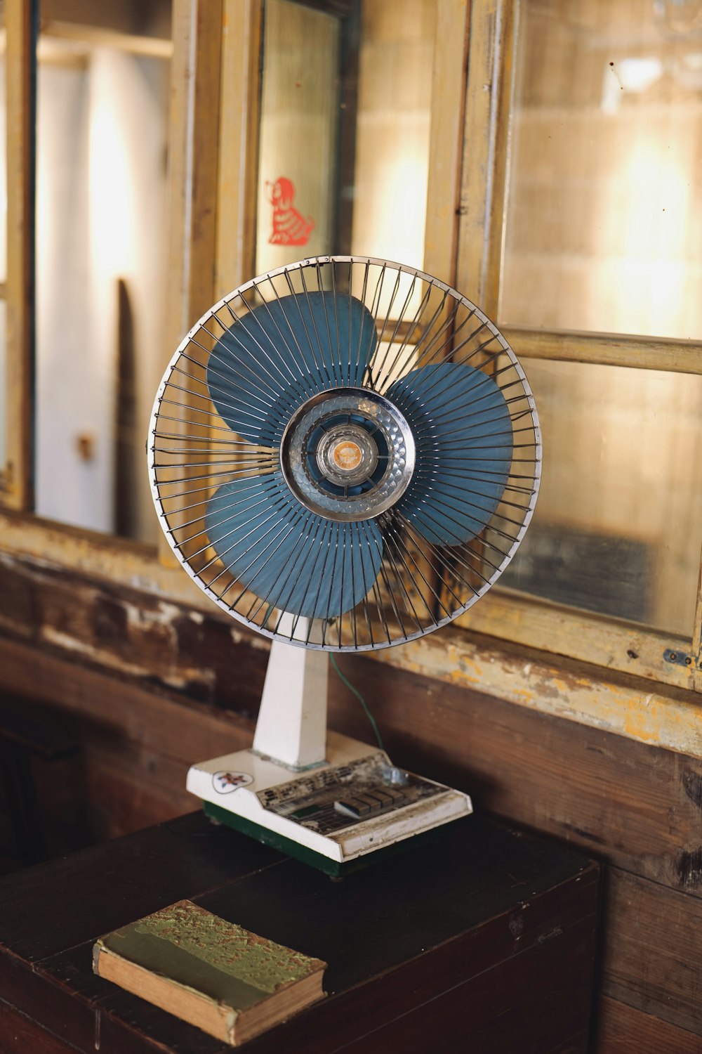 a blue fan sitting on top of a wooden table
