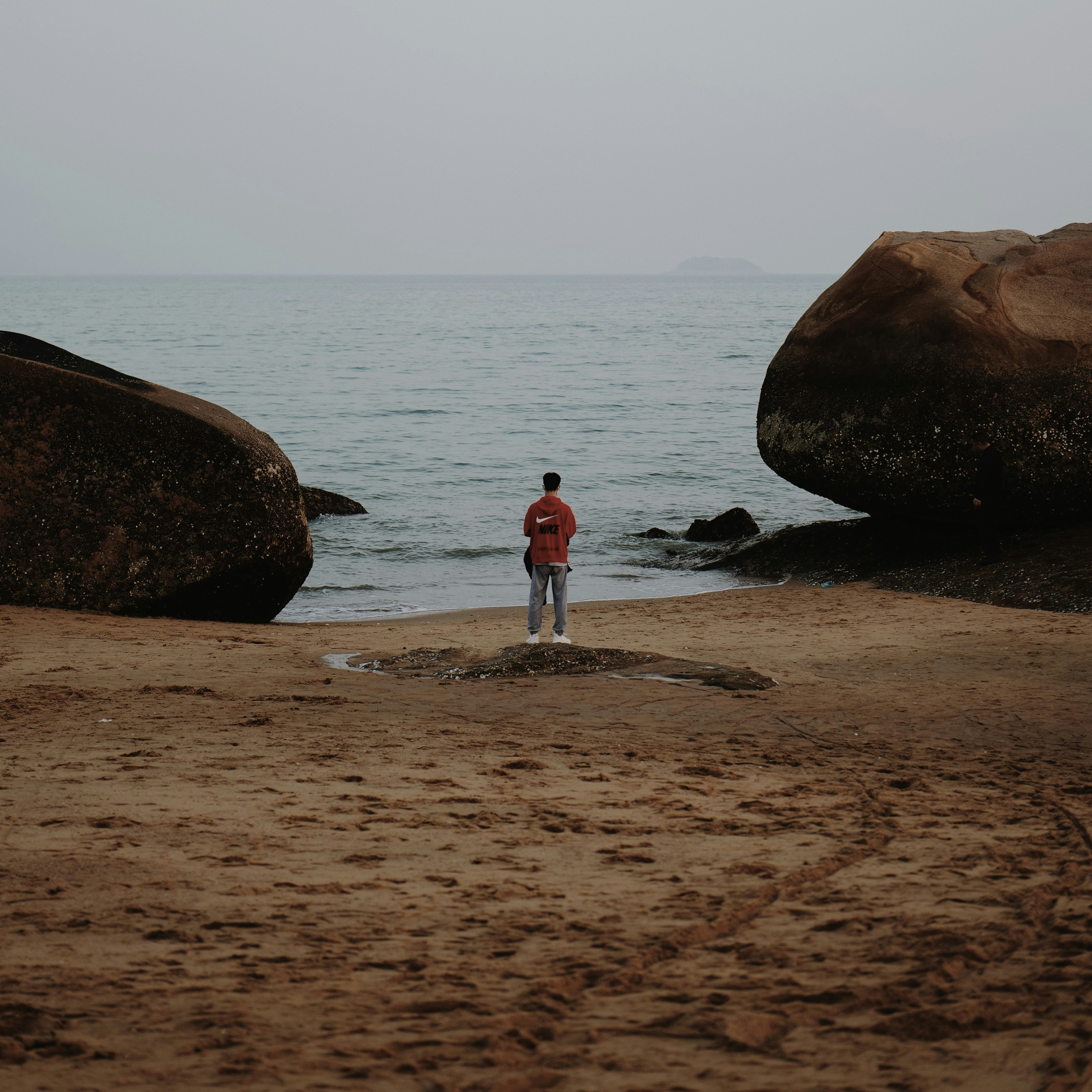a man standing on a beach next to the ocean