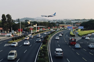a large jetliner flying over a busy highway