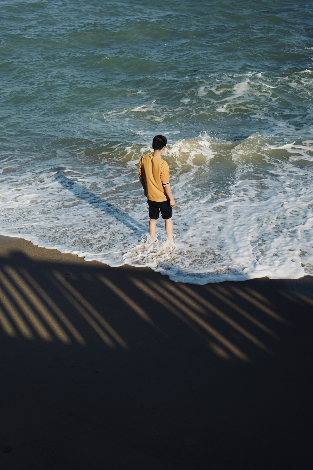 a man standing in the water at the beach