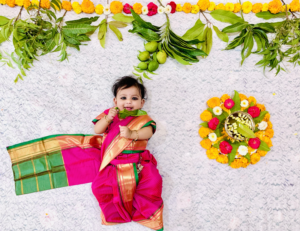 a little girl laying on the ground next to a wreath