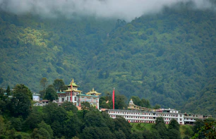 a large building on top of a lush green hillside