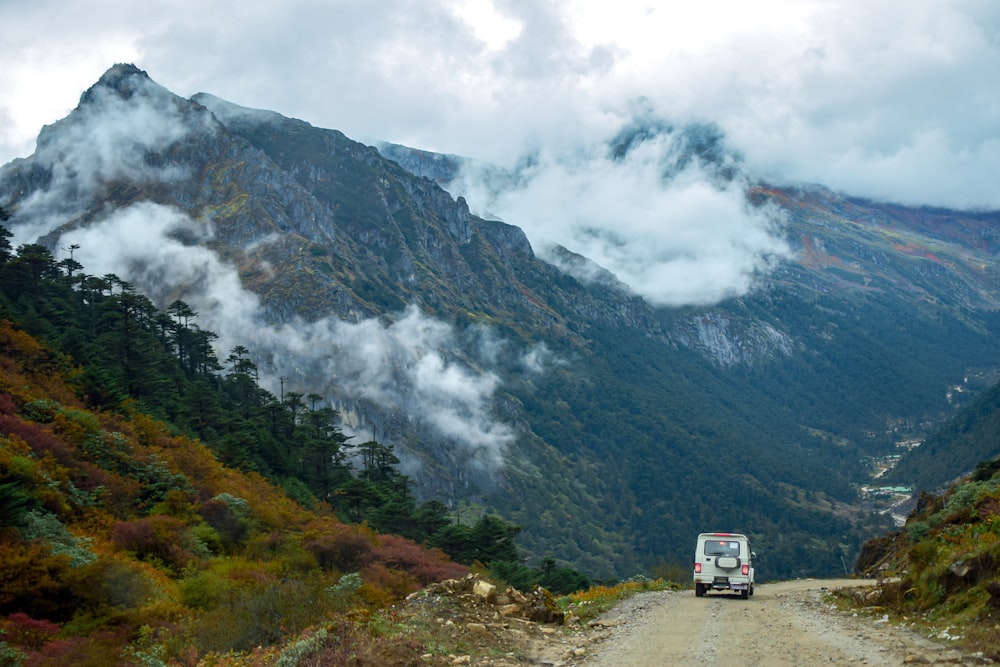 a van driving down a dirt road in the mountains