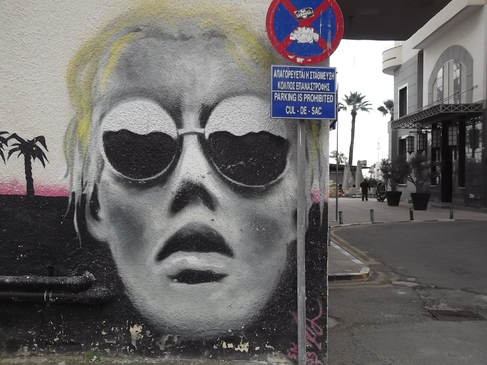 a painting of a woman with sunglasses on a street corner