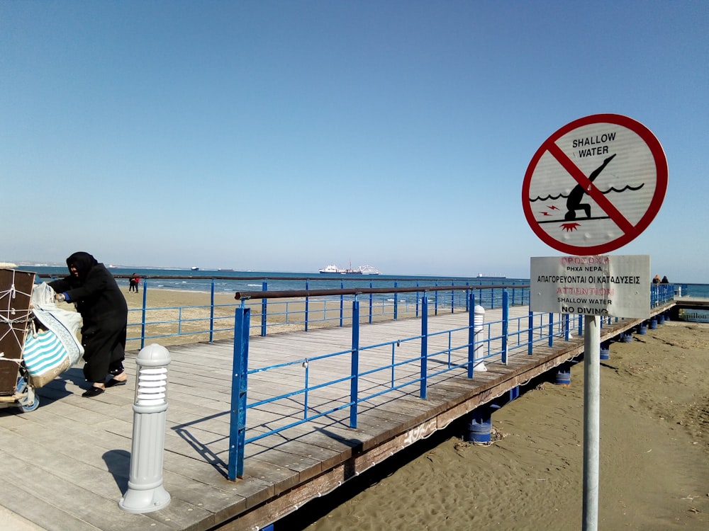 a person standing on a pier next to the ocean