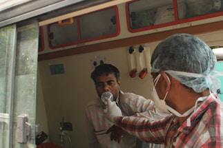 a man in a surgical mask and a man in a hospital room