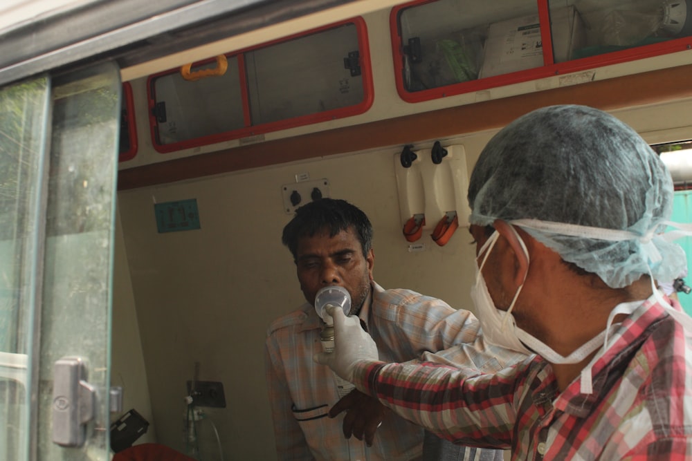 a man in a surgical mask and a man in a hospital room
