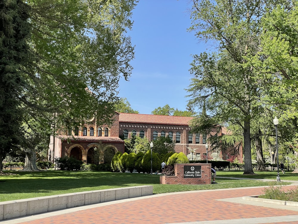 a large brick building surrounded by trees and grass