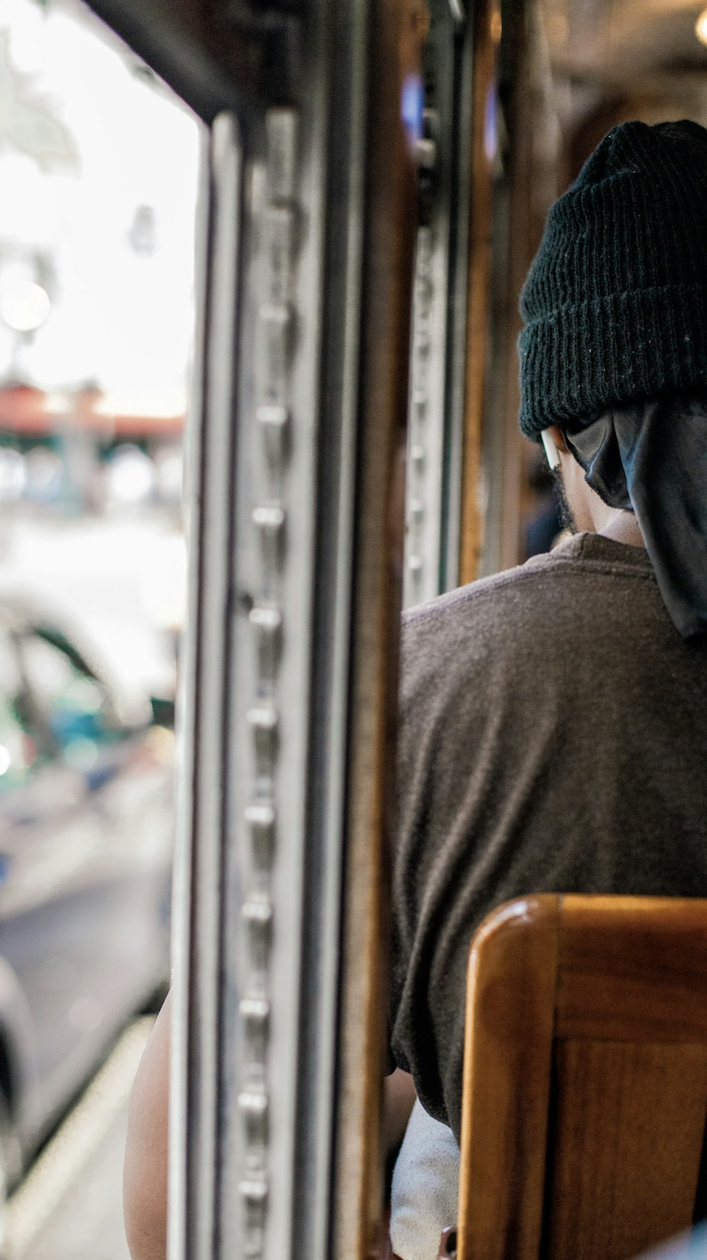 um homem sentado em um ônibus olhando pela janela