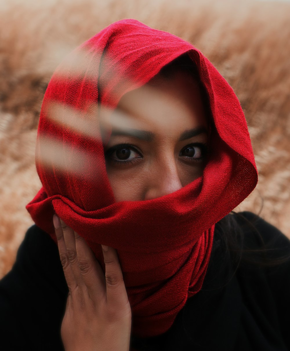 a woman wearing a red scarf covering her face