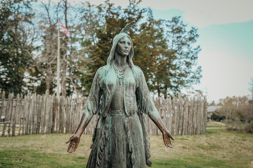 a statue of a woman standing in a field