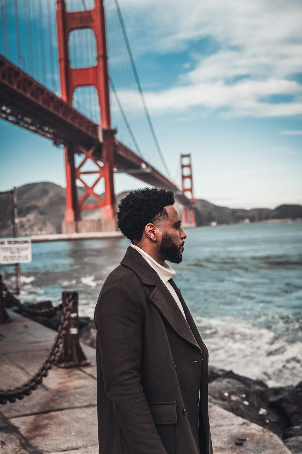 a man standing in front of the golden gate bridge