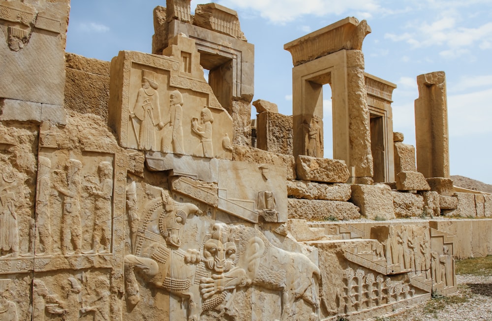 a stone wall with carvings and statues on it