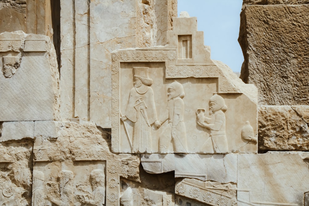 a close up of a stone wall with carvings on it