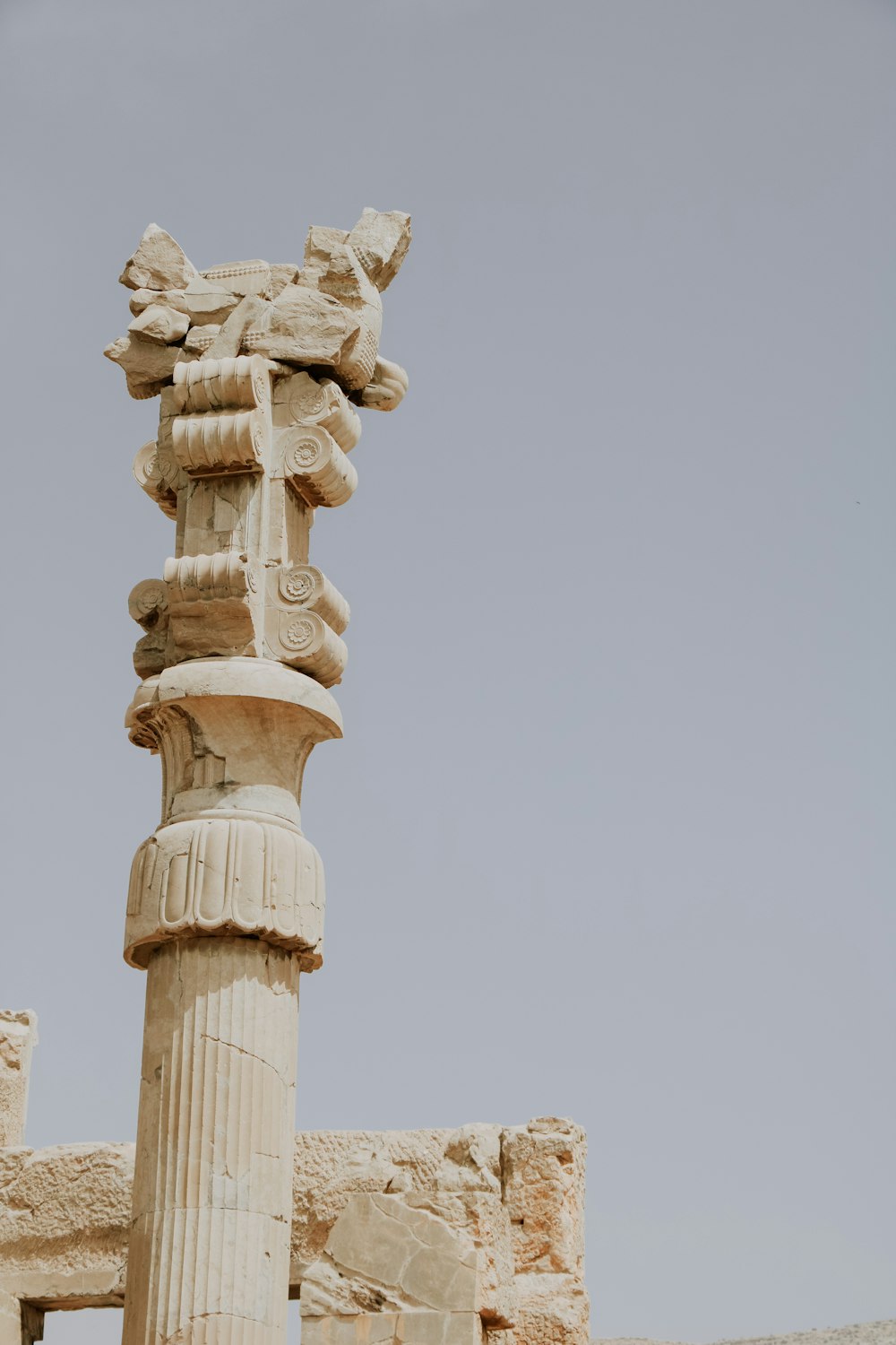 a tall white pillar with a statue on top of it