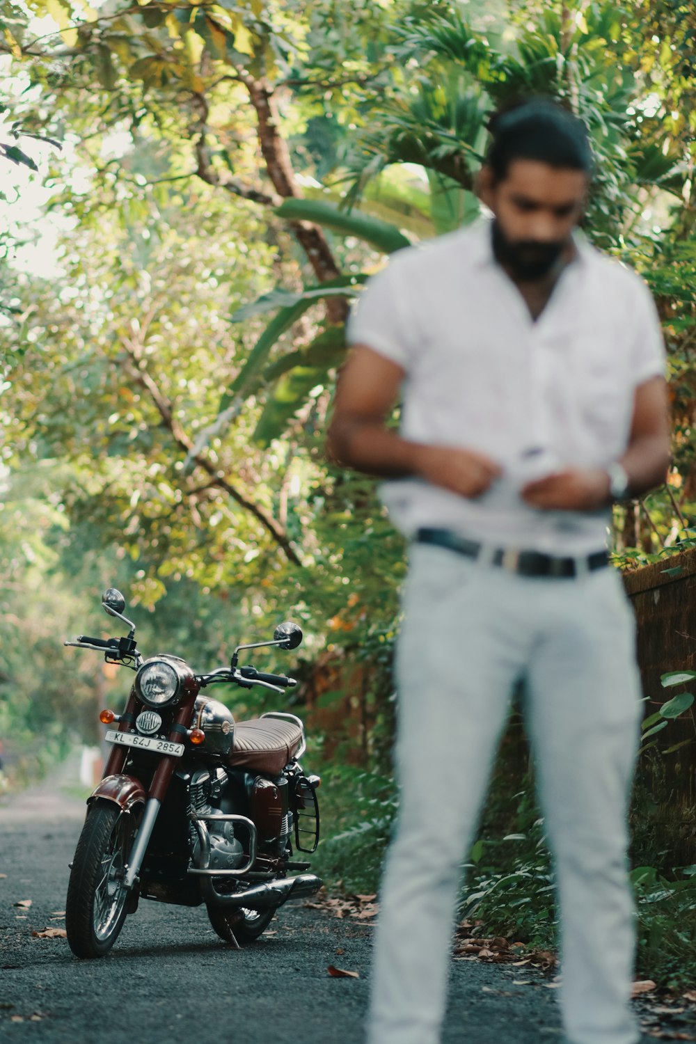 a man standing next to a motorcycle on a road