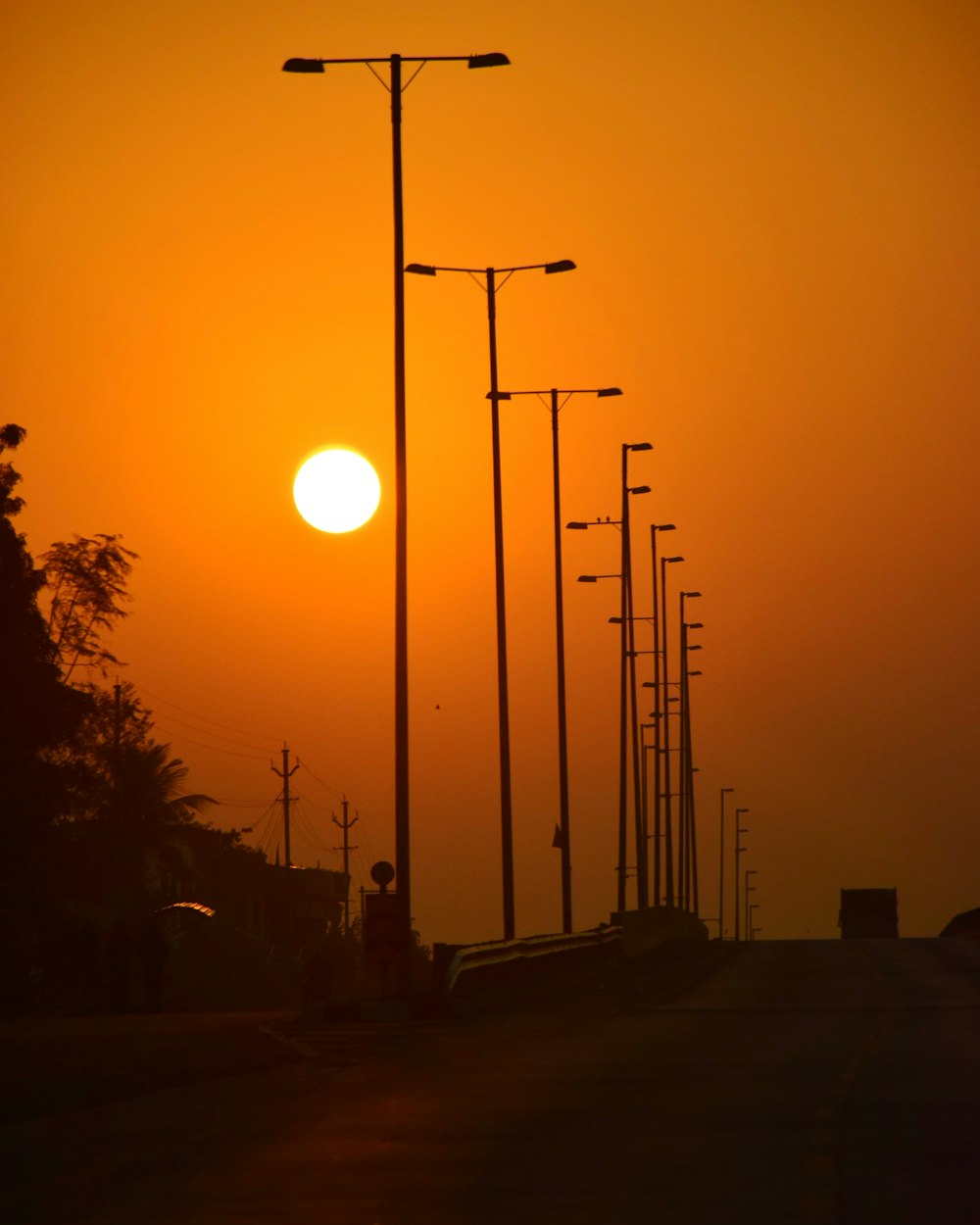 the sun is setting over a city street