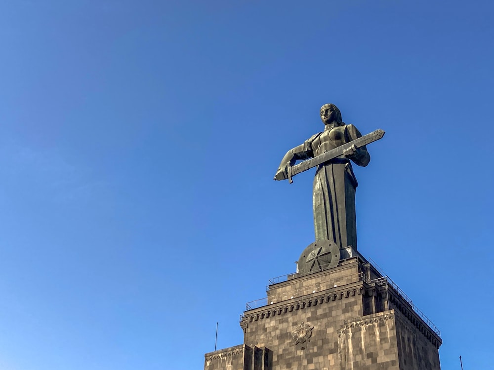 a statue of a man holding a sword on top of a building