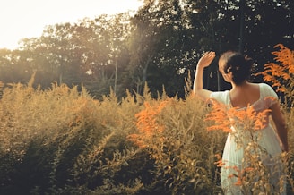 a woman standing in a field of tall grass