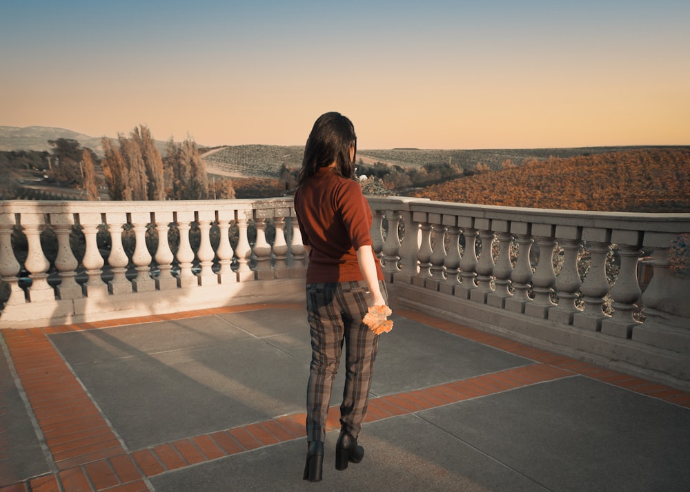 a woman standing on top of a balcony next to a railing