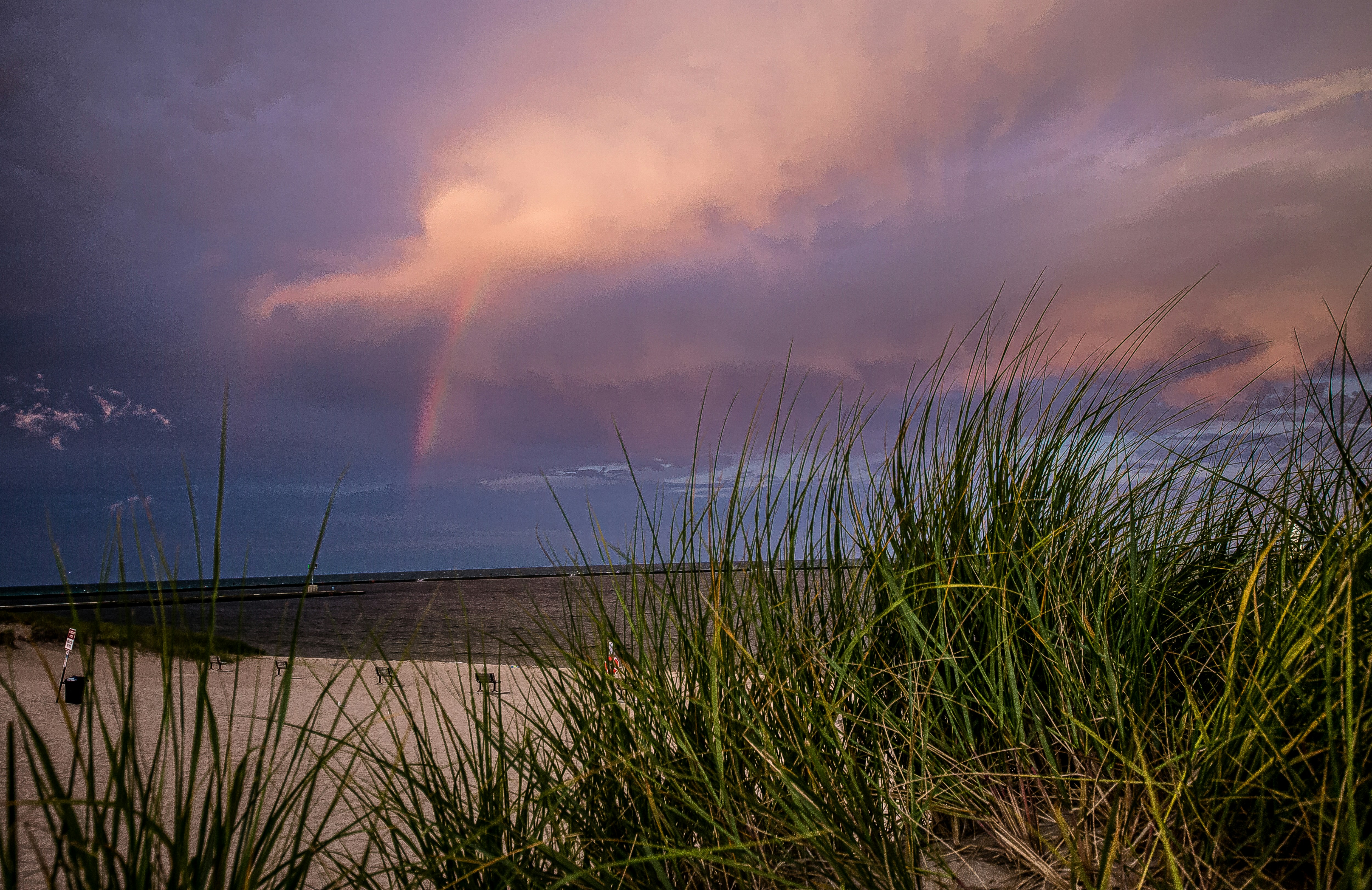 a rainbow in the sky over a beach
