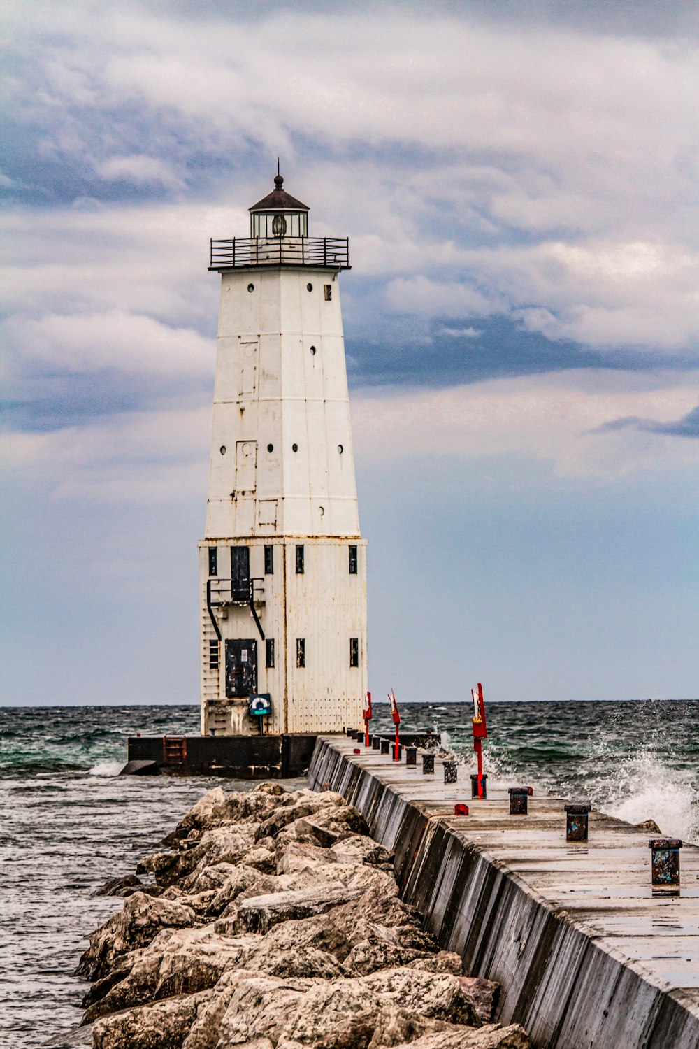 a light house sitting on top of a pier next to the ocean